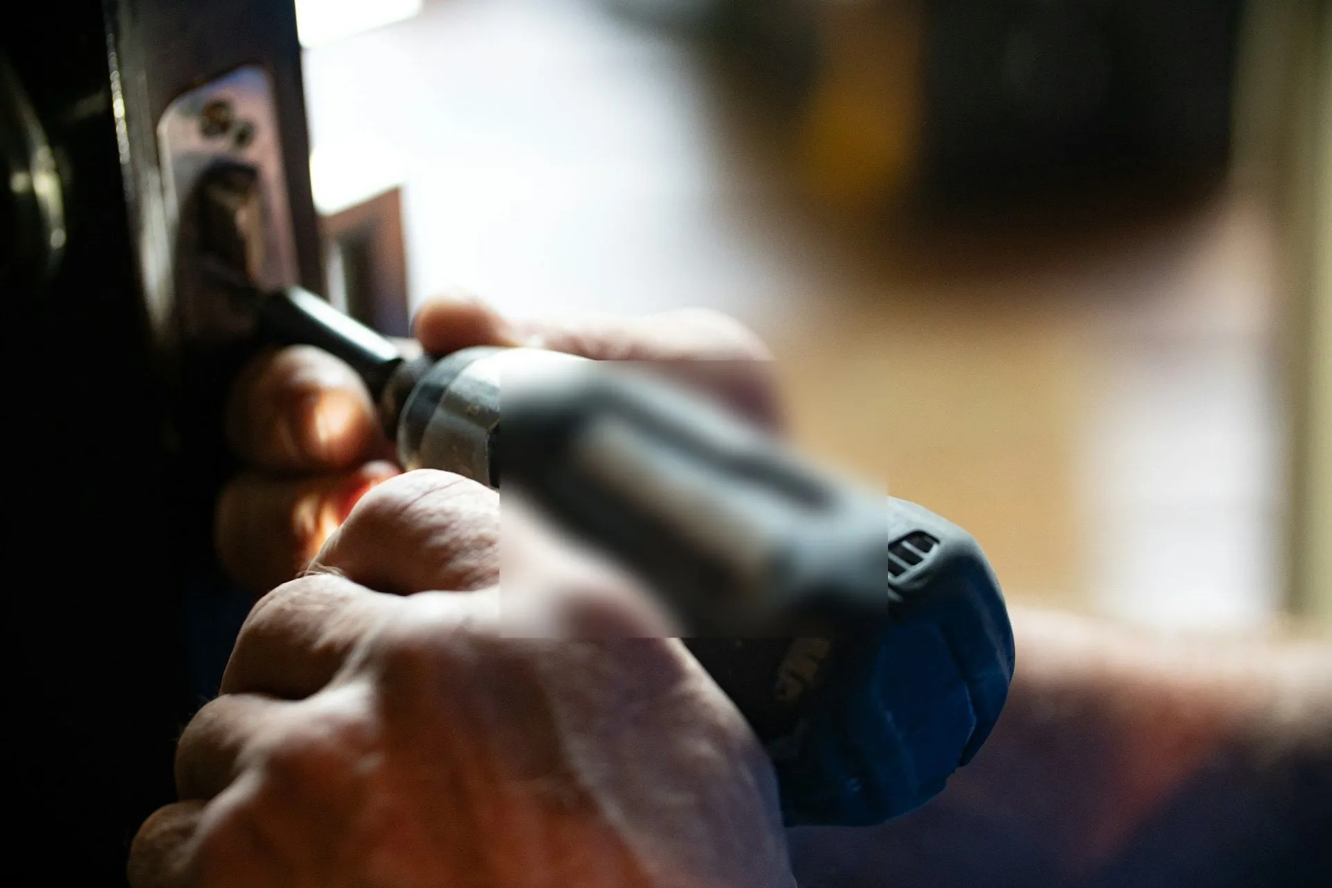 Handyman using a power tool to repair a door